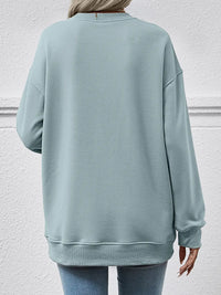 Light blue sweatshirt worn by a person against a light gray wall