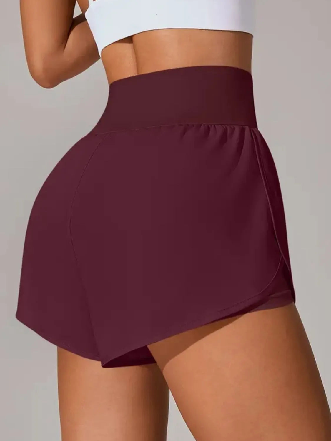 Maroon athletic skirt worn by a person on a plain background