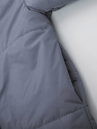 Close-up of a gray quilted jacket with a white background