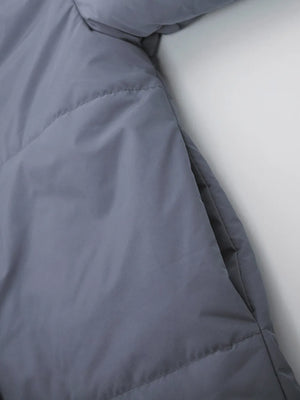 Close-up of a gray quilted jacket with a white background