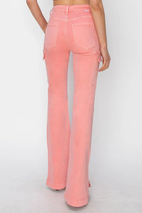 Person wearing pink flared jeans on a white background