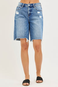 Blue denim shorts worn by a person on a white background