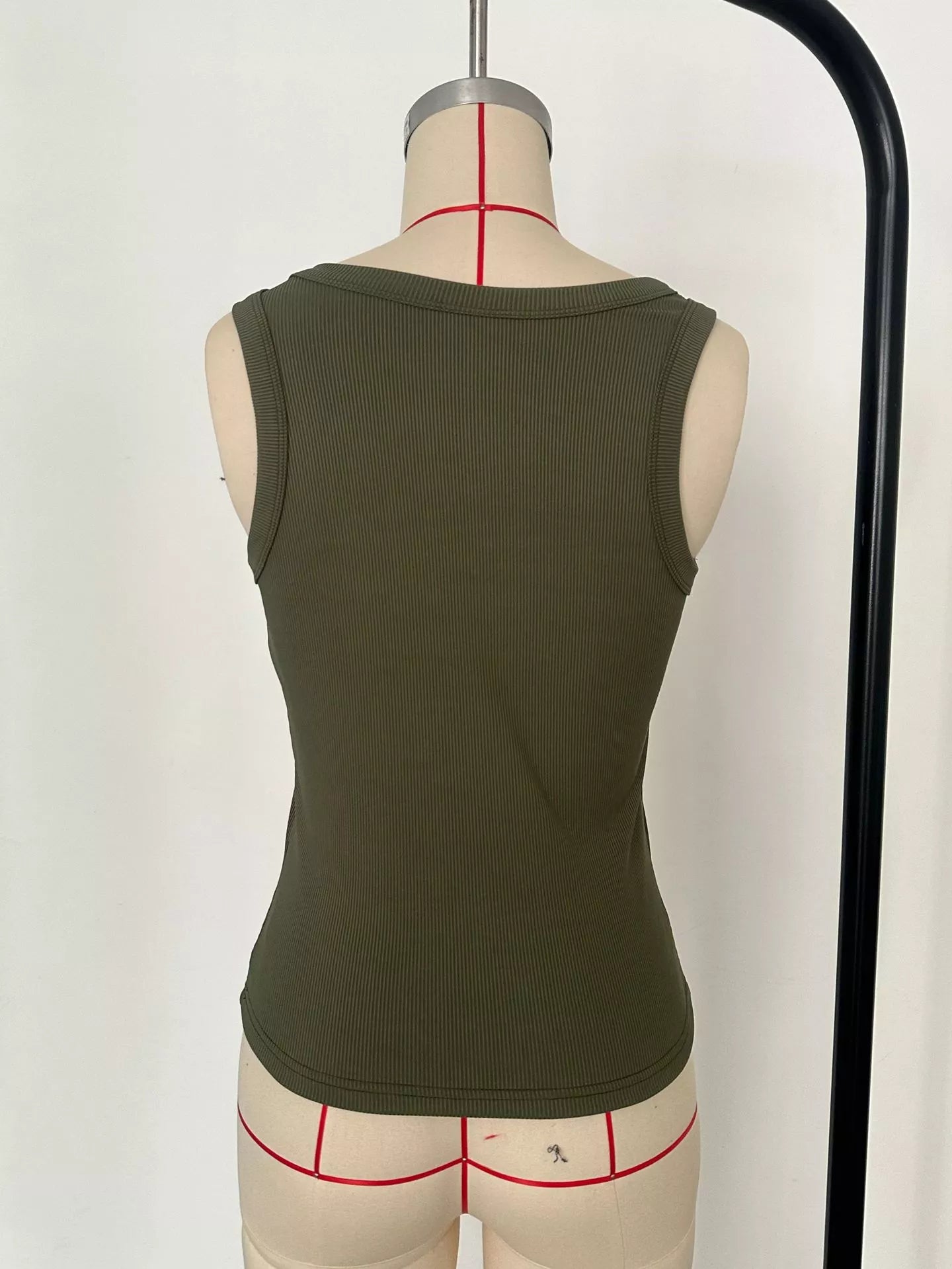 Green tank top on a mannequin with underwear underneath against a white background