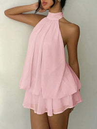 Pink halter neck dress on a plain background