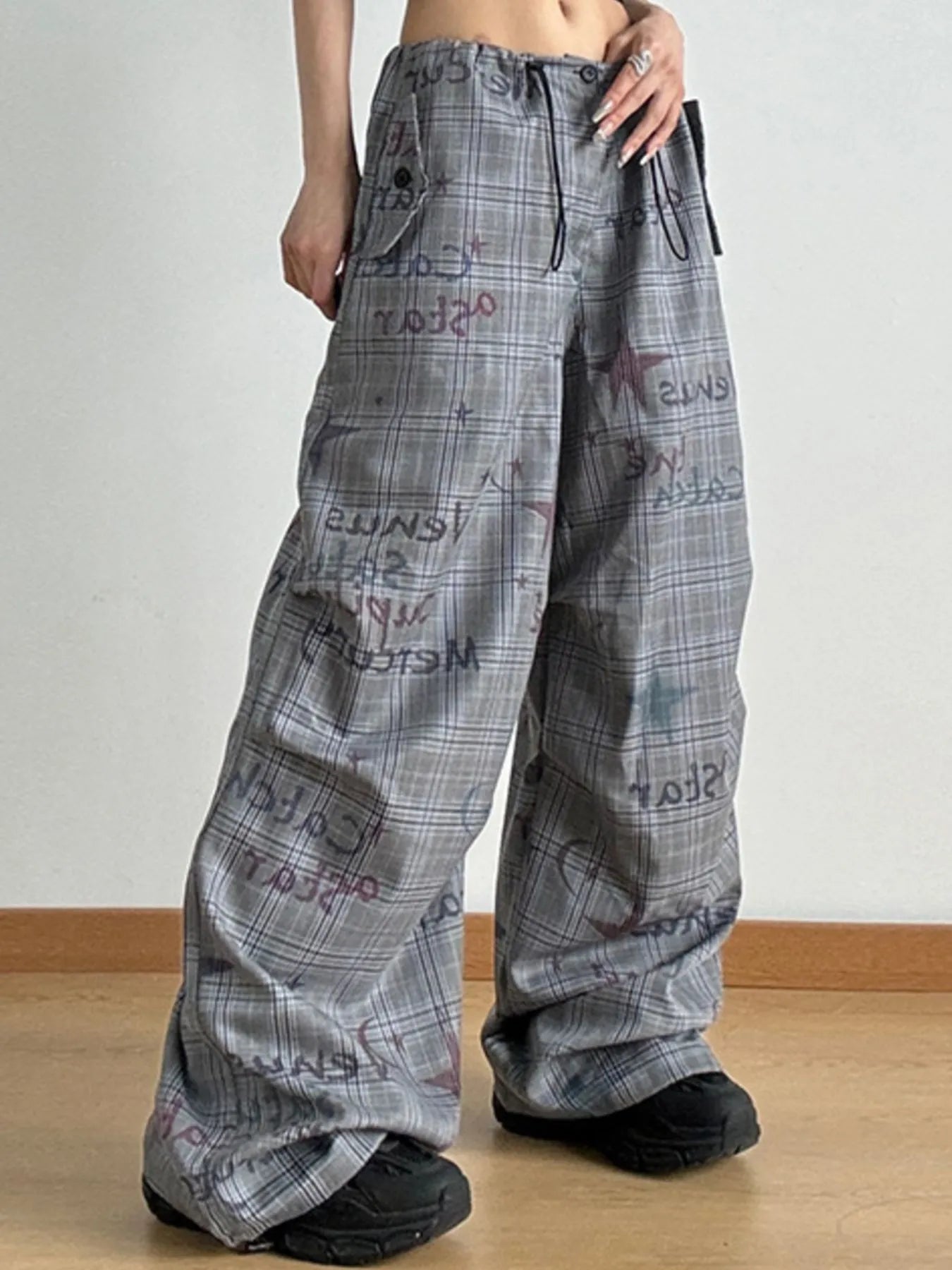 Plaid pants with text pattern worn by a person on a plain background