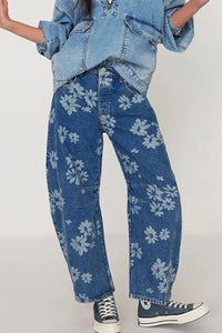 Person wearing blue floral jeans and denim jacket on a white background