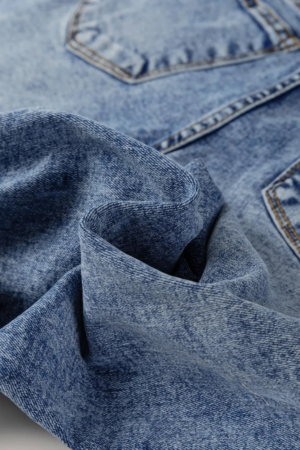 Close-up of blue denim fabric with stitching details