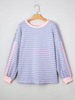 Blue and pink striped shirt on a hanger against a gray background