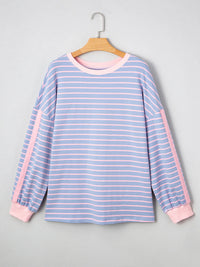 Blue and pink striped shirt on a hanger against a gray background