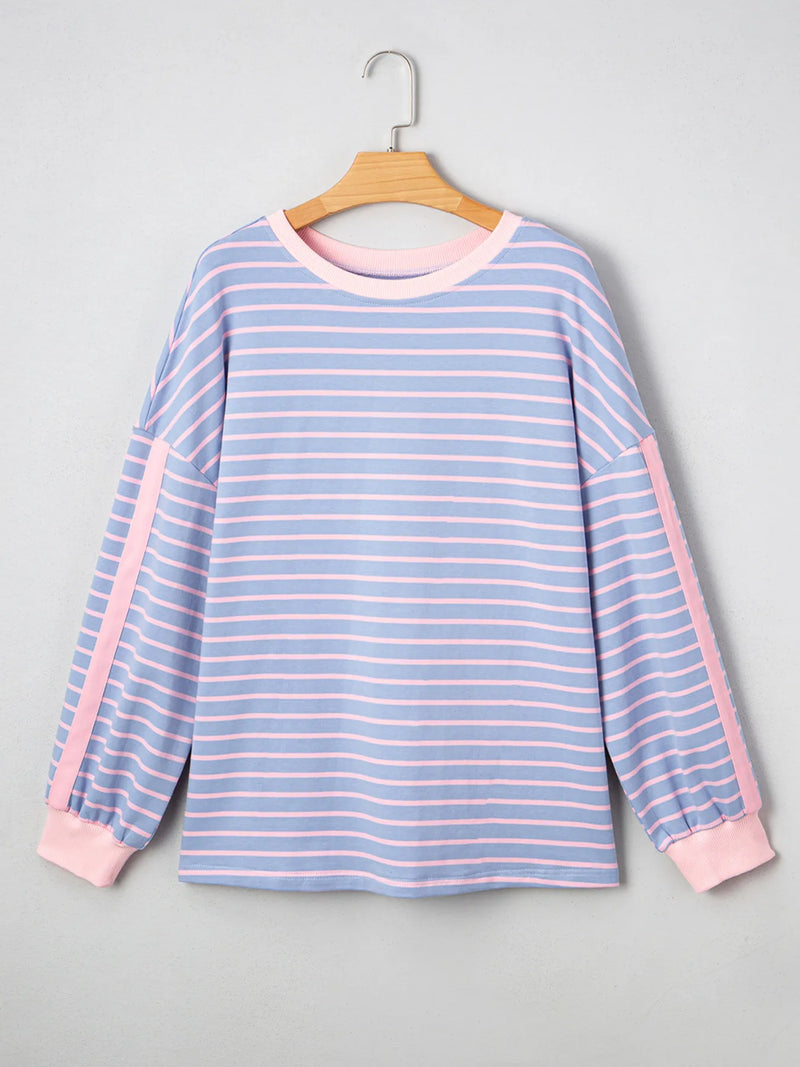 Blue and pink striped shirt on a hanger against a gray background