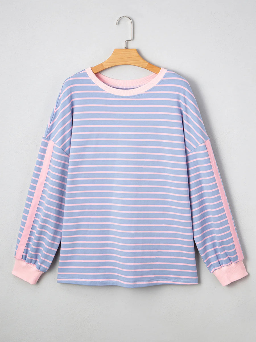 Blue and pink striped shirt on a hanger against a gray background