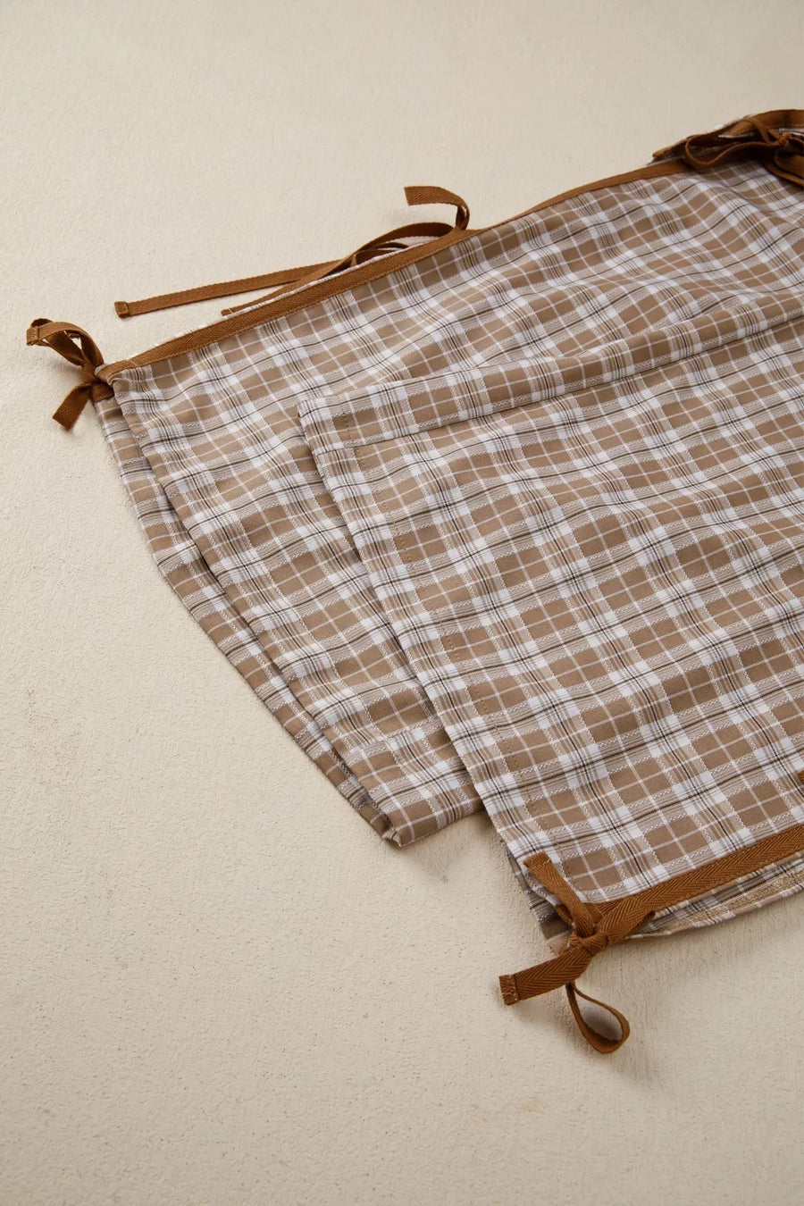 Plaid fabric with brown straps on a beige background