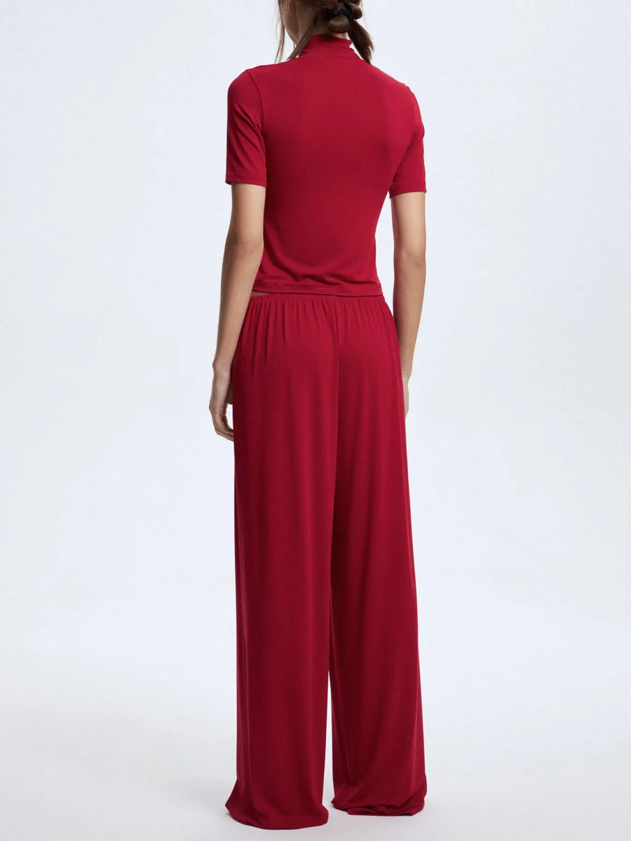 Red jumpsuit worn by a person on a white background