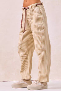 Beige striped pants worn by a person on a plain background