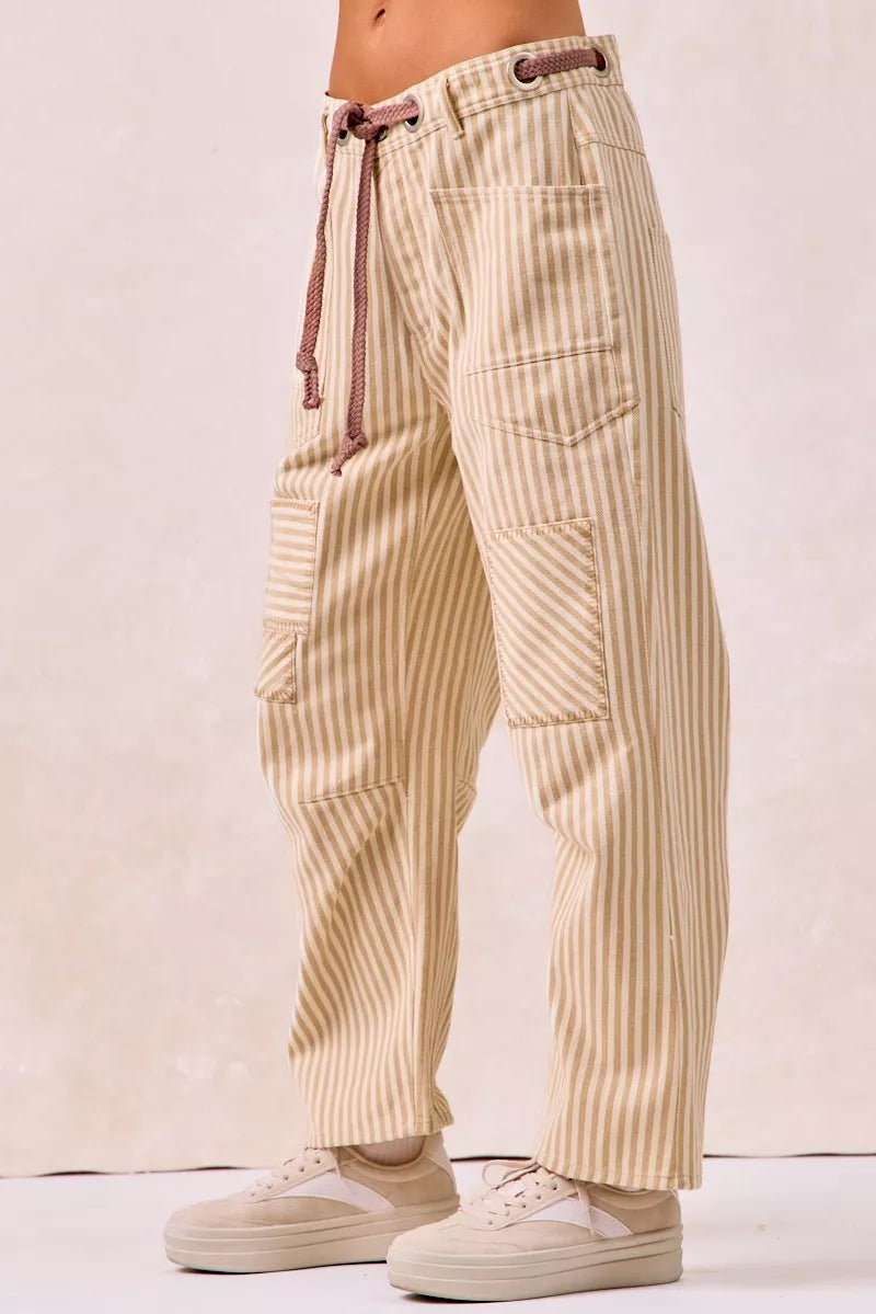 Beige striped pants worn by a person on a plain background