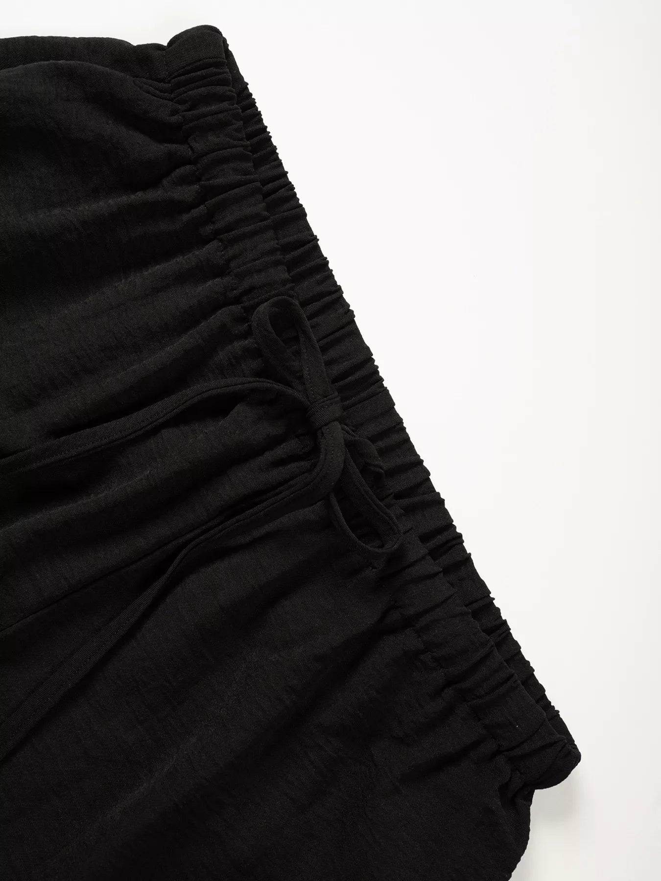 Black fabric with ruched texture on a white background
