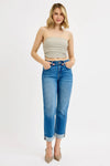 Woman wearing a strapless top and blue jeans on a white background