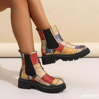 Colorful patchwork boots on a neutral background
