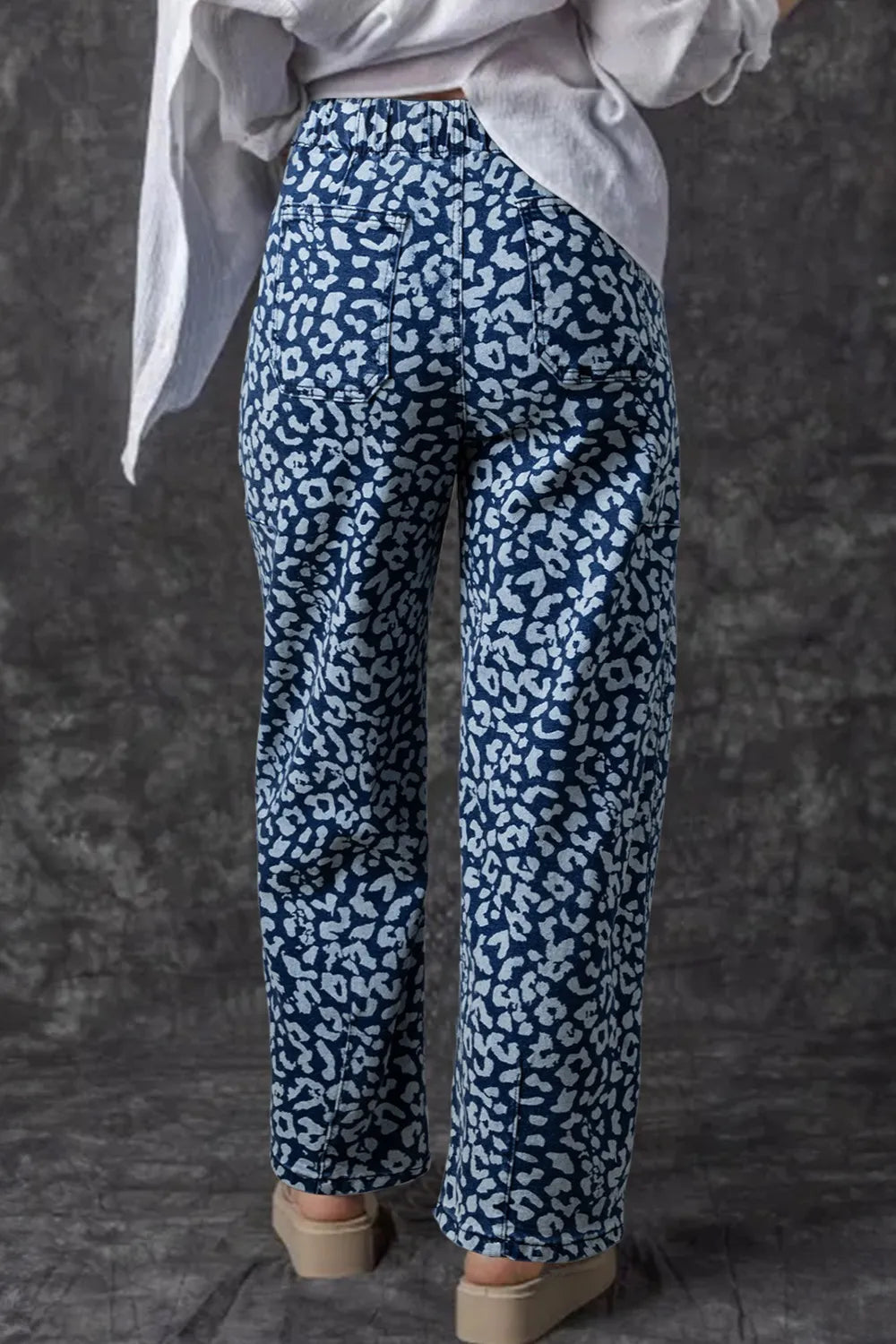 Person wearing blue patterned pants on a dark background