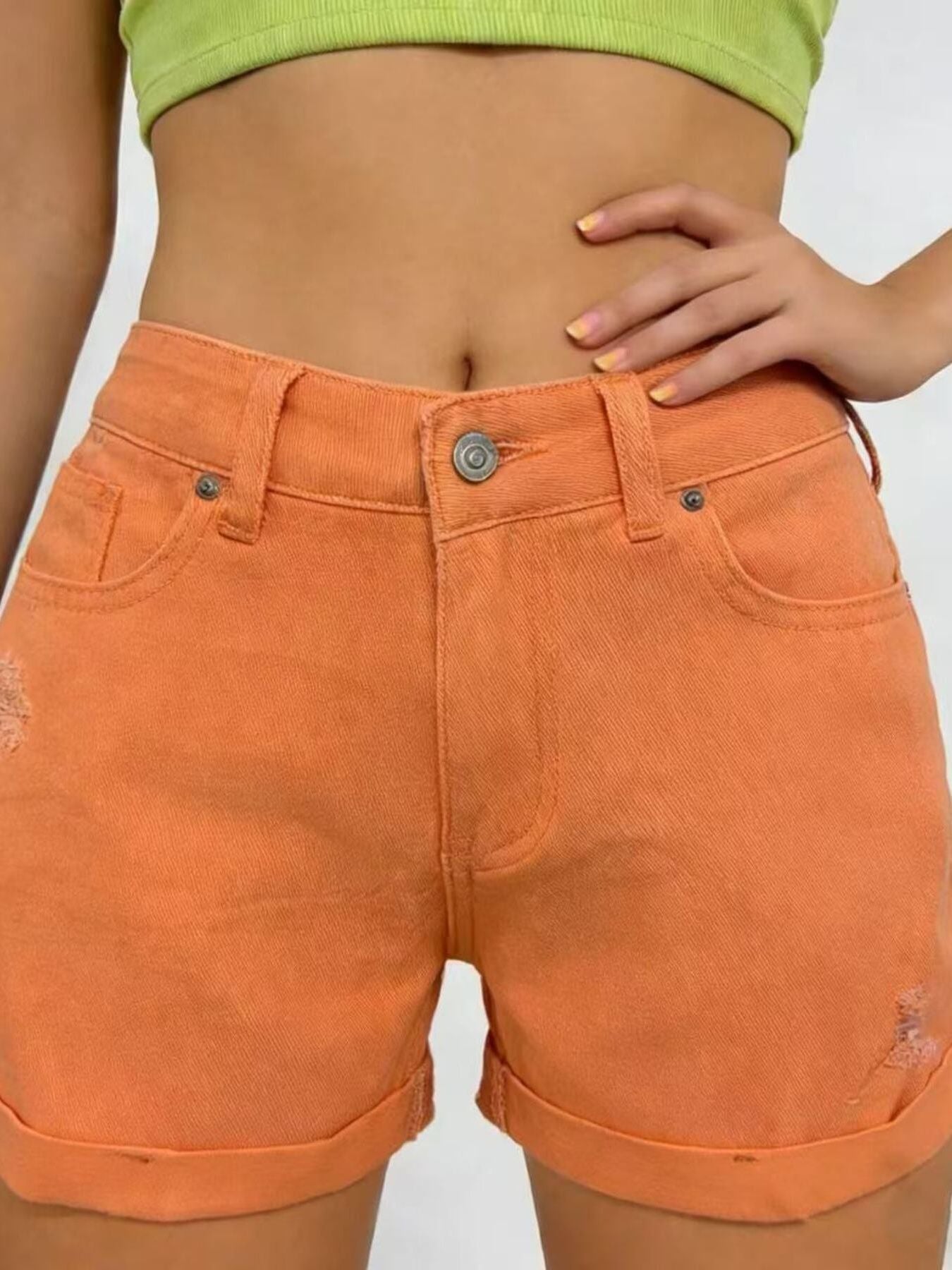 Person wearing orange shorts on a plain background