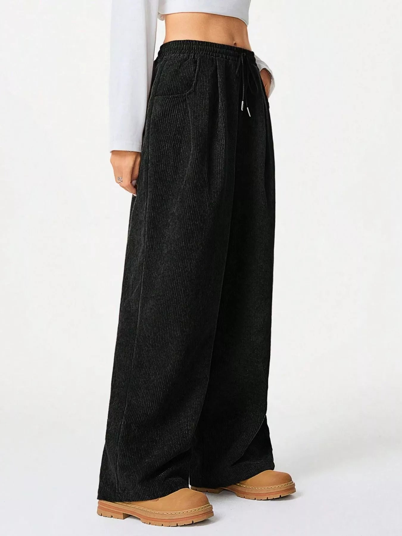 Black wide-leg pants worn by a person on a white background