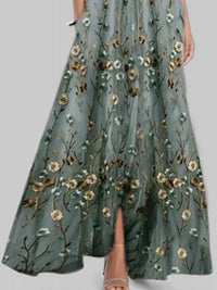 Green floral embroidered dress on a plain background