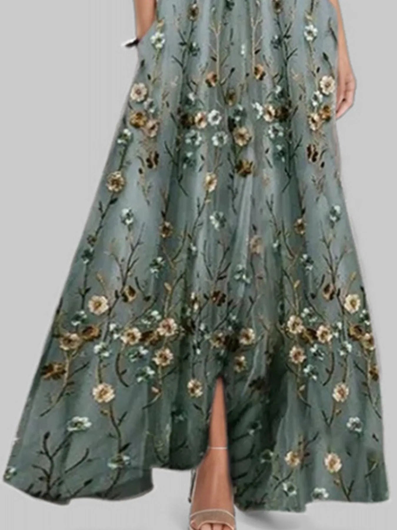 Green floral embroidered dress on a plain background