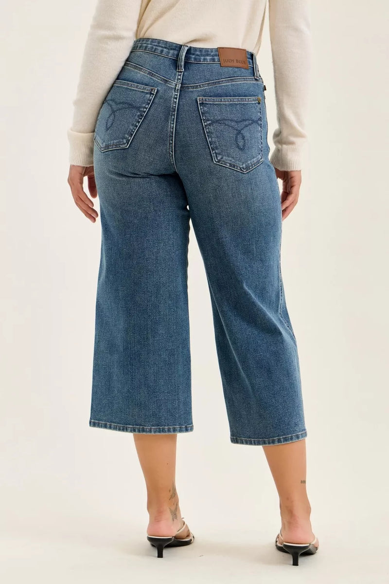 Person wearing blue jeans on a plain background