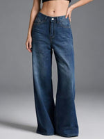Person wearing blue wide-leg jeans on a gray background
