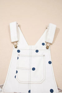 White denim overalls with blue polka dots on a beige background