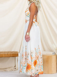 Woman wearing a floral dress with a white curtain background