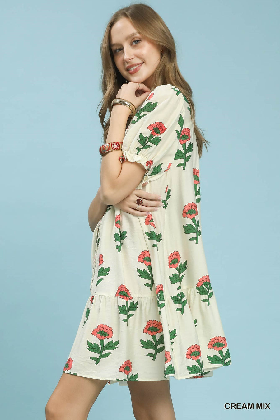 Woman wearing a floral dress against a light blue background