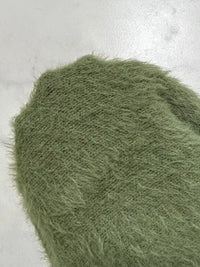 Close-up of green textured fabric on a light gray background