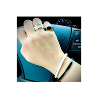 A lady driving a car wearing B.Tiff "The Hamptons" White Enamel Gold Bangle Bracelet