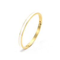 A gold-colored bangle bracelet with a white enamel center, displayed against a white background.