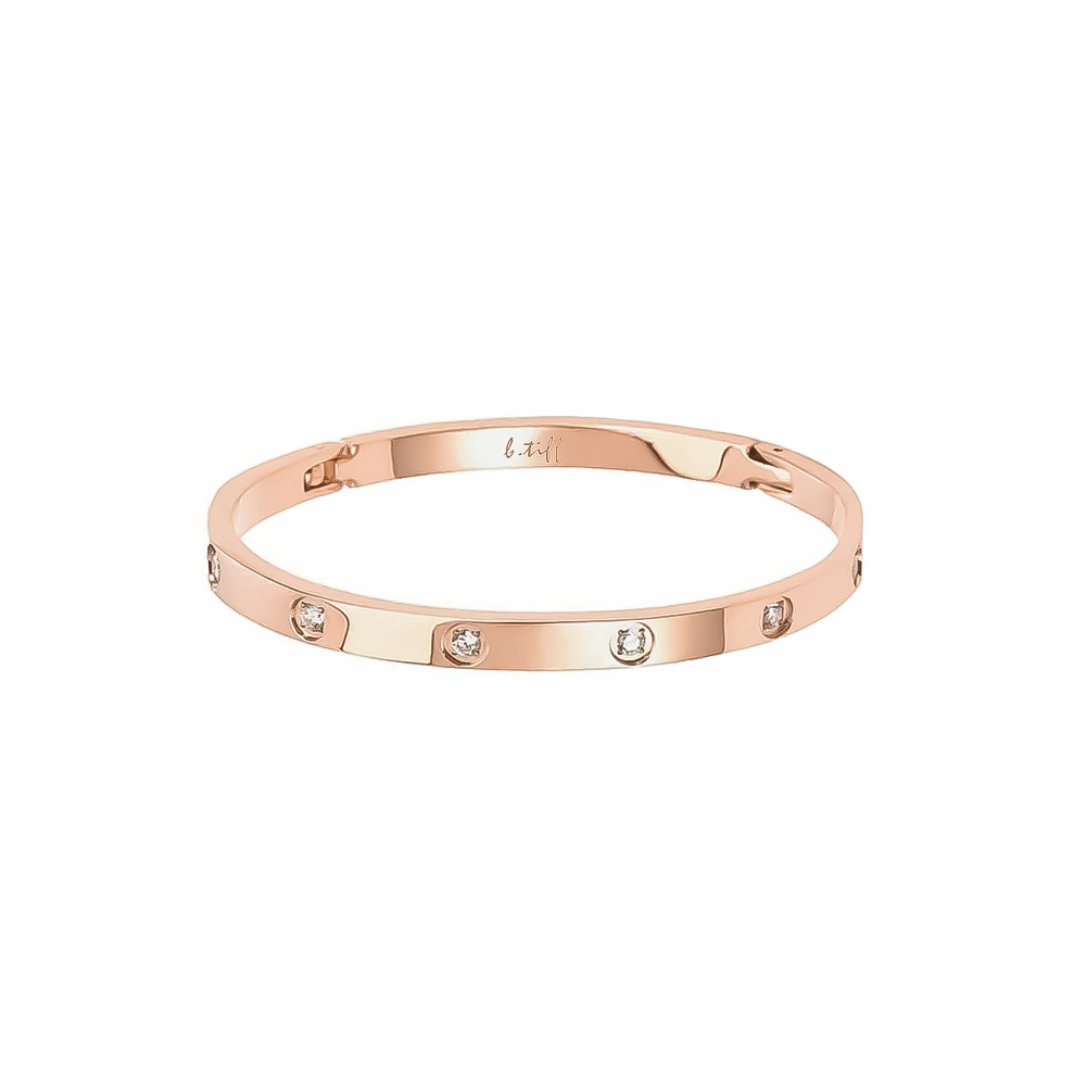 A rose gold bangle bracelet with eight stone embellishments, featuring a polished finish.