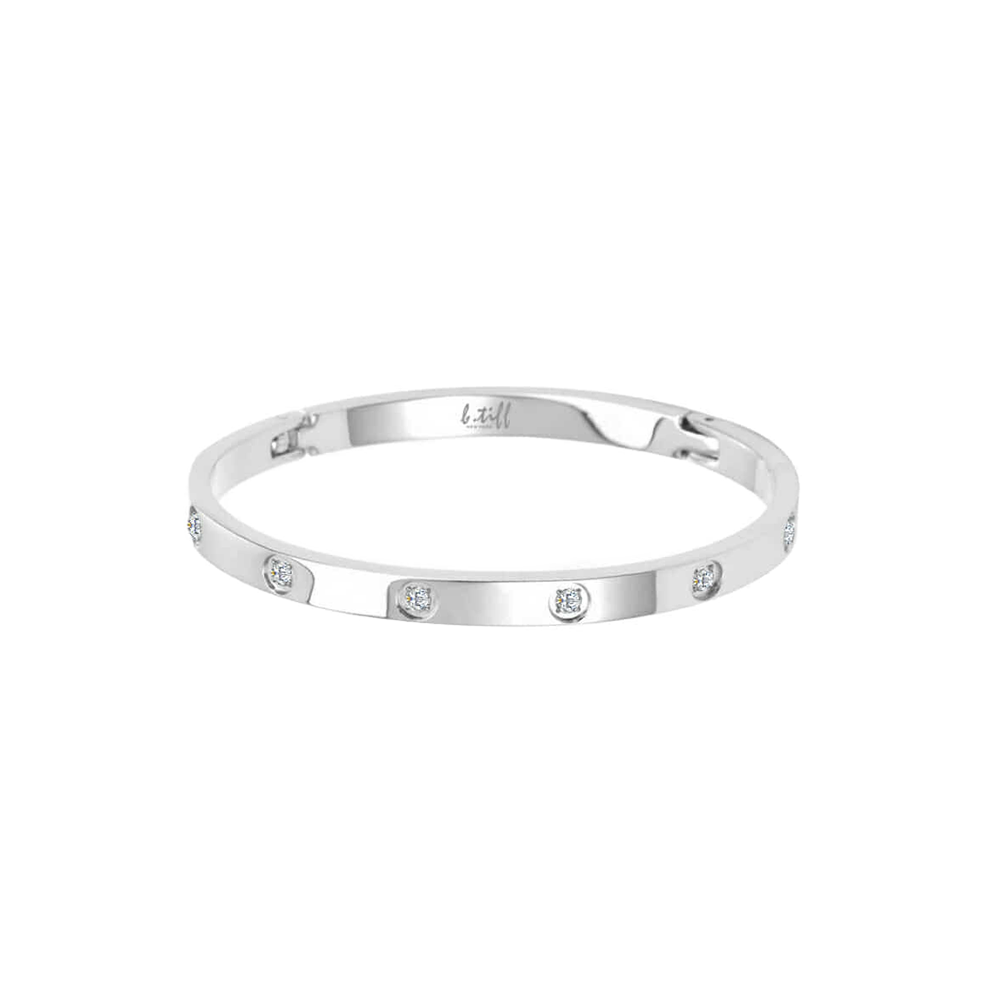 A polished silver bangle bracelet with eight stone accents, arranged in a pattern around the bracelet.