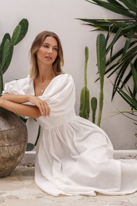 Woman sitting with leaning on a plant Cherie Puff Sleeve Midi Dress