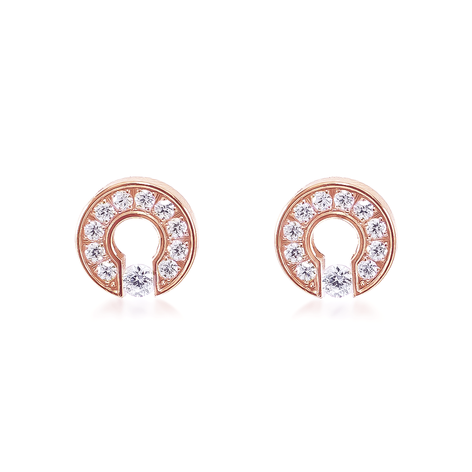 A pair of rose gold-colored barrel earrings with pavé of smaller stones around the edge.
