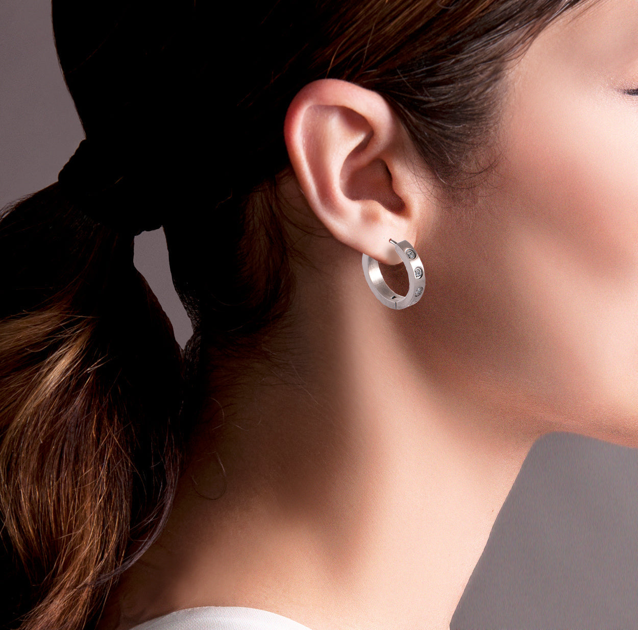 A view of silver  B.Tiff Pavé 16-Stone Hoop Earrings in a woman's ear