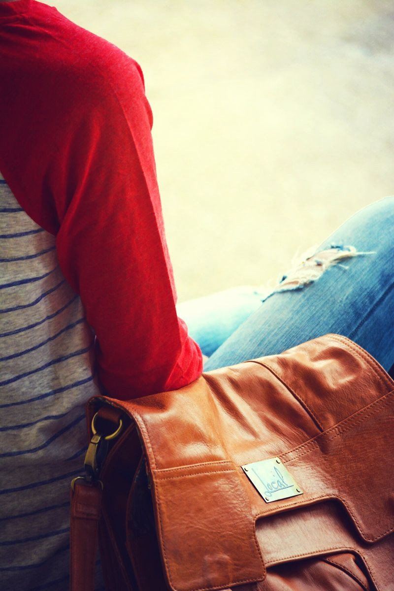 A woman sitting with Mi Vida Foldover Tote by her side