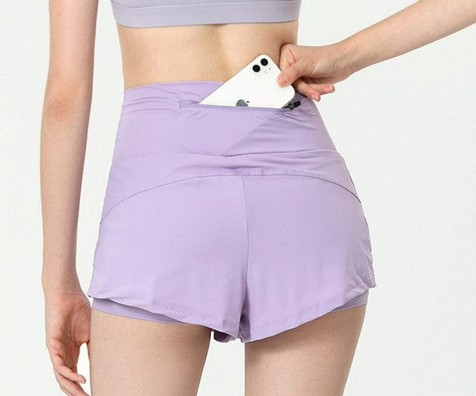 view of the back pocket of Active Shorts with Back Zipper Pocket -purple with a cell phone in it
