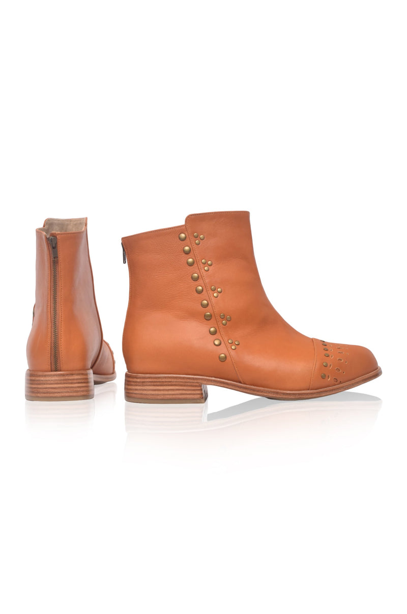 Pair of brown leather boots with studded details on a white background