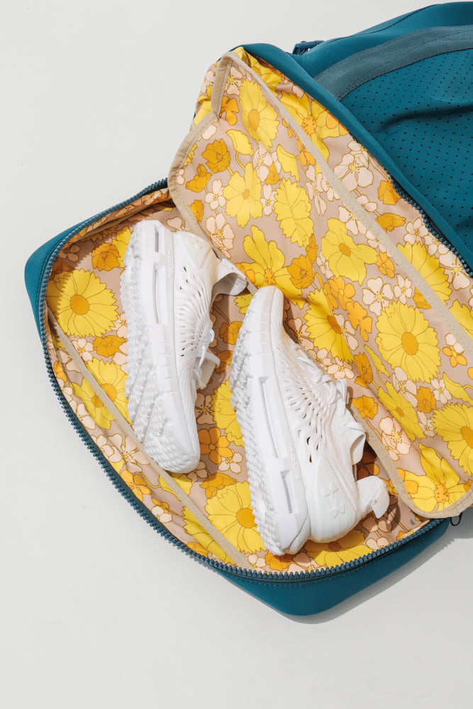 View of a compartment in Ella Duffle  showing white sneakers