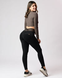 Woman wearing black leggings with a subtle pattern on a white background