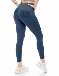 Blue leggings with pockets worn by a person on a white background