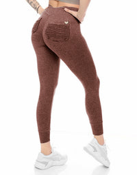 Brown leggings with pockets worn by a person on a white background