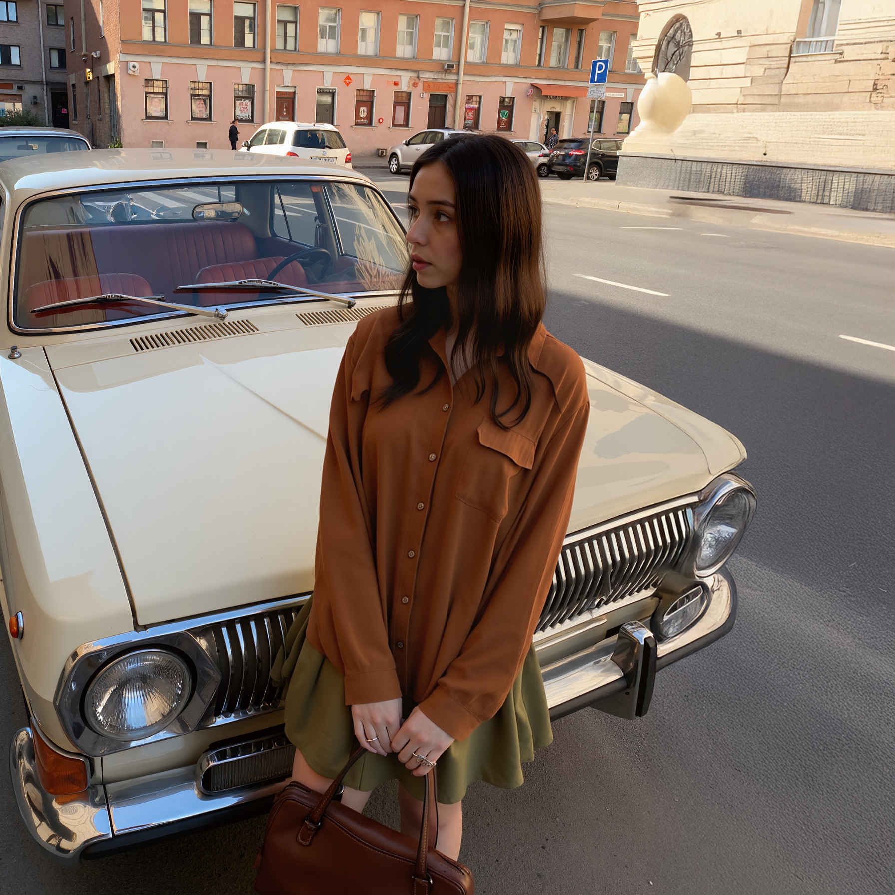 Woman standing next to a vintage car on a city street