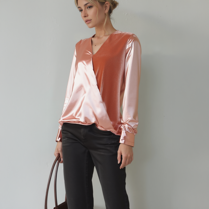 Woman wearing a two-tone blouse with a plain background