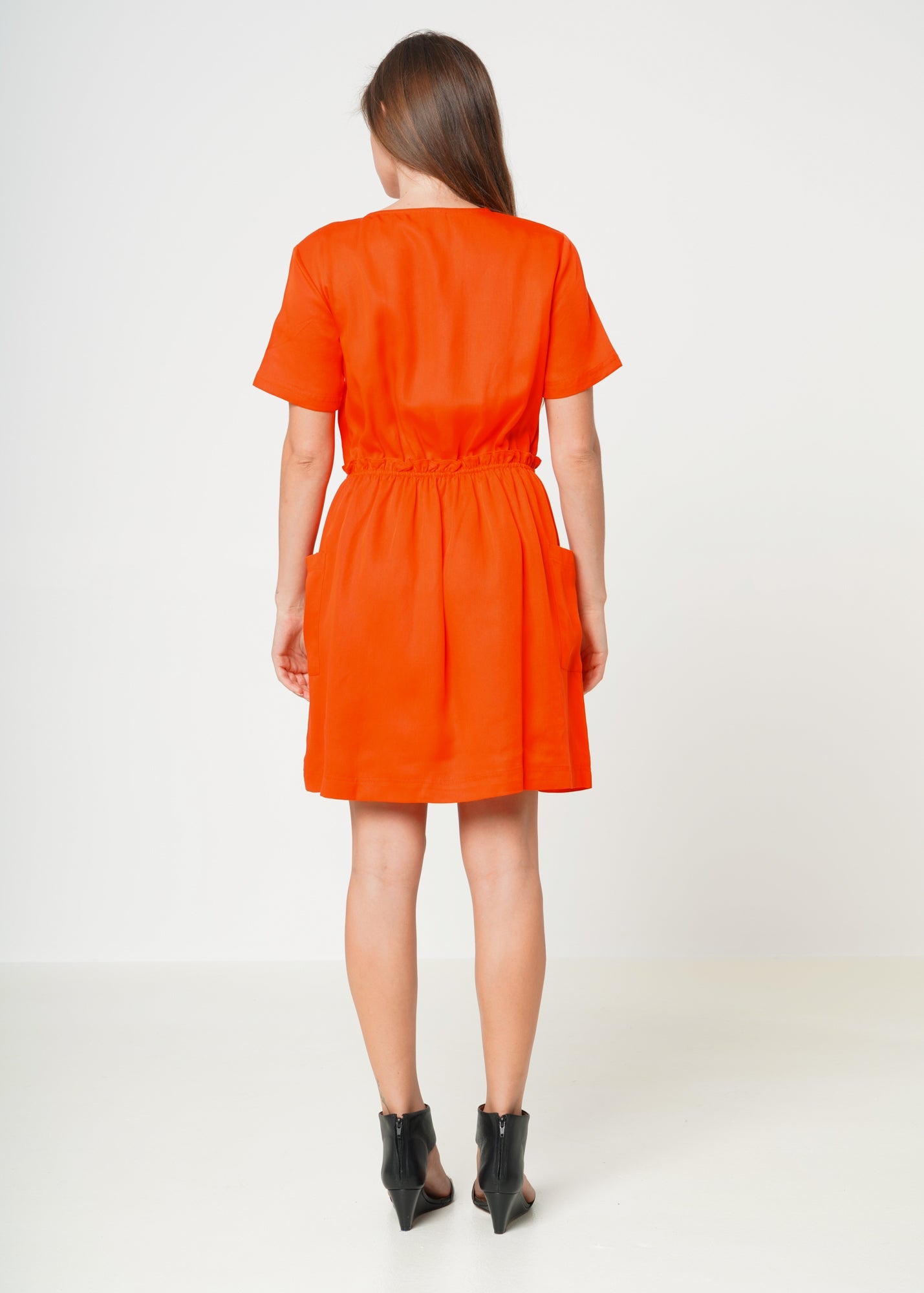 Model showing the back of Women's Short Sleeve Utility Dress in Poppy